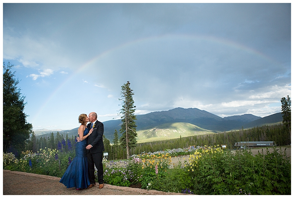 Bride and Groom on top of a mountain with a rainbow