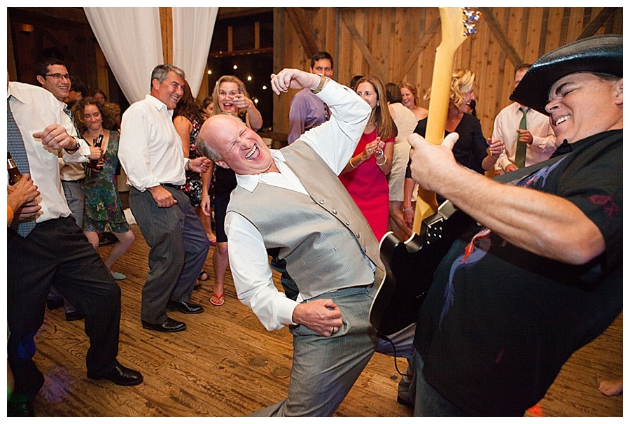 Father of the bride plays air guitar with the band at the wedding