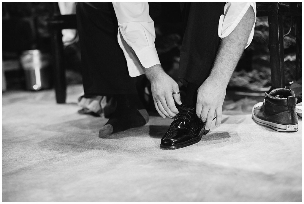 Groom lacing up his dress shoe